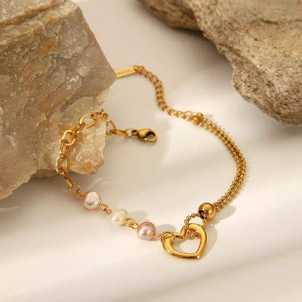 Gold heart and pearl bracelet displayed flat