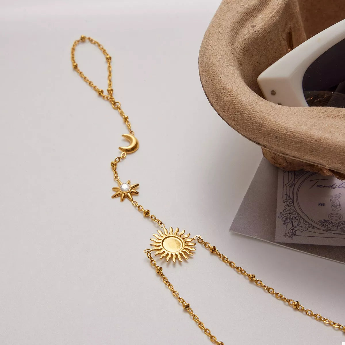 Close-up of the sun motif and fine chain links