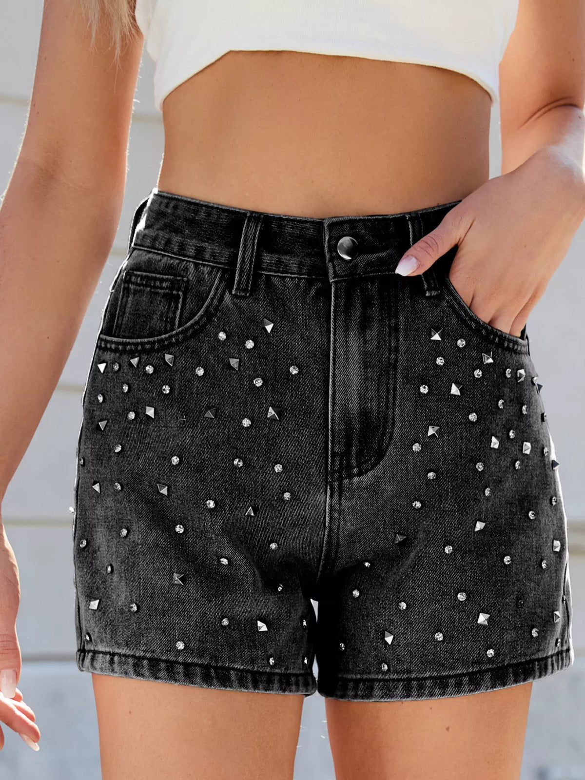 Close front view of black high-waisted denim shorts with scattered silver-coloured studs