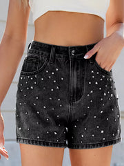Close front view of black high-waisted denim shorts with scattered silver-coloured studs