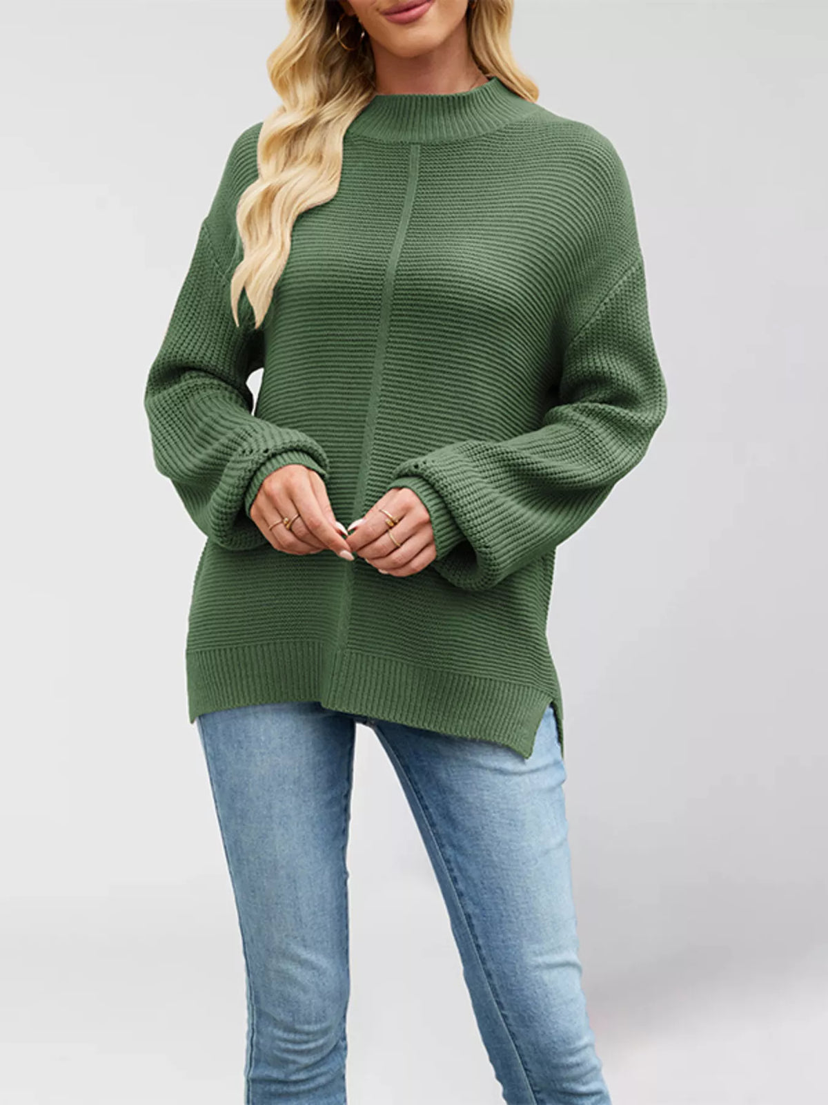 Women’s ribbed mock-neck drop-shoulder sweater in green front view with hands clasped