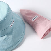 Mint green and pink wide-brim hats shown close-up, with the pink hat folded.
