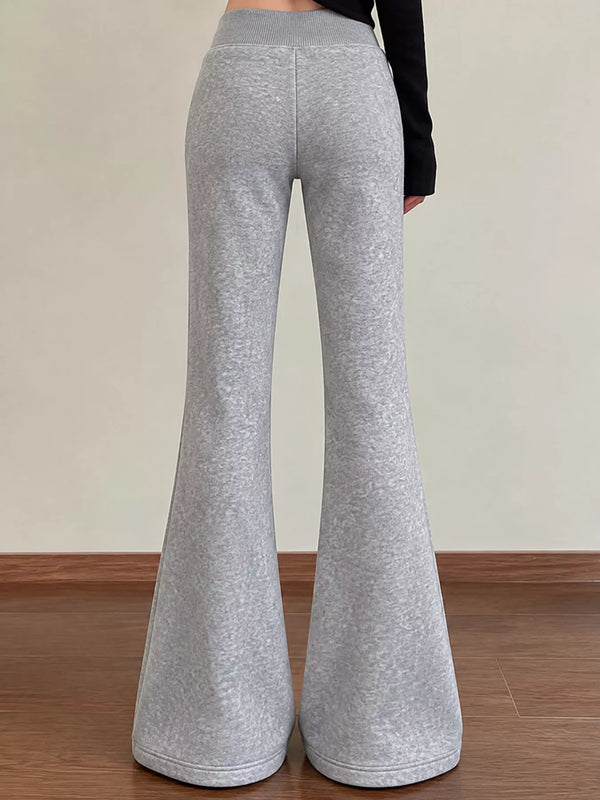 Rear view of grey flared trousers showing wide legs and an elastic waistband