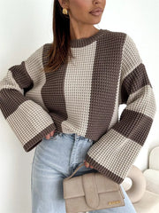 Model wearing a cream and taupe oversized sweater with wide vertical panels