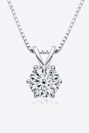 Round clear-stone solitaire pendant on a silver-tone chain against white