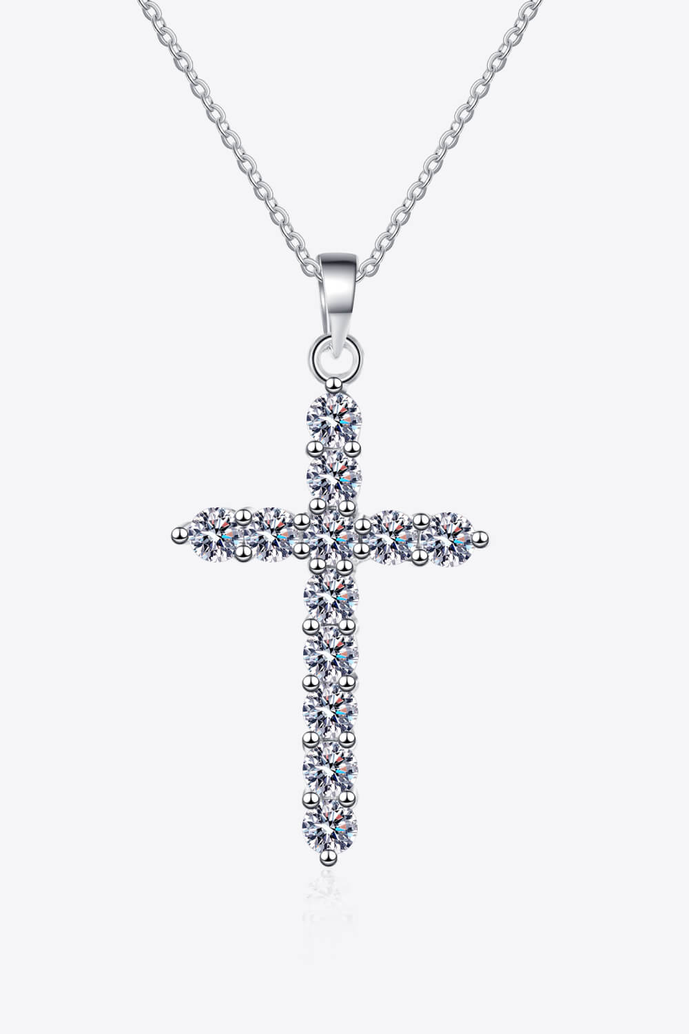 Front view of a clear-stone cross pendant necklace on white