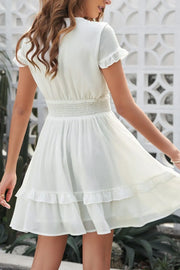Front view of white dress showing bow and ruffled hem