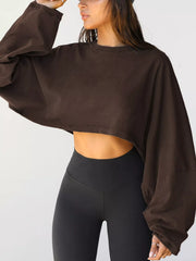 Dark brown cropped sweatshirt worn with black leggings, side view