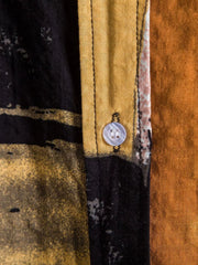 Close-up of a button on the black and ochre shirt placket