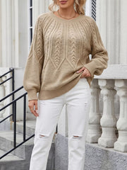 Beige cable-knit sweater worn with white jeans, front view