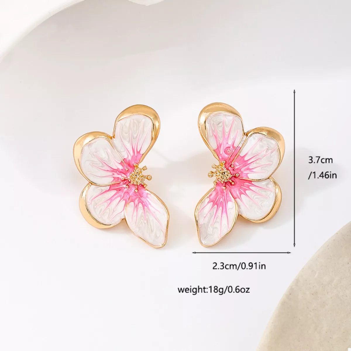 Pair of pink-and-white flower studs with size markings shown