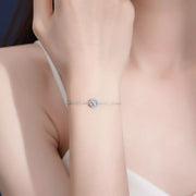 Silver chain bracelet with a single round moissanite center worn on a wrist