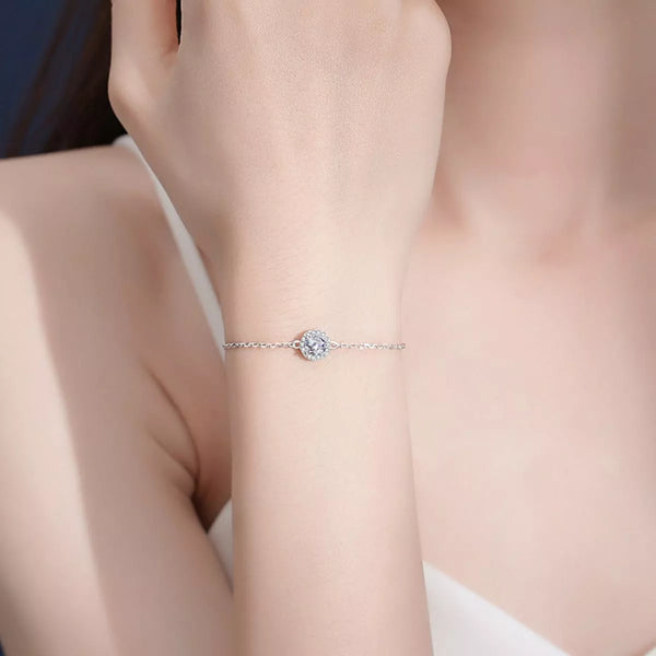 Silver chain bracelet with a single round moissanite center worn on a wrist