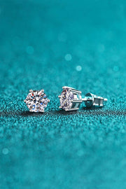 Pair of moissanite stud earrings shown in side profile on teal