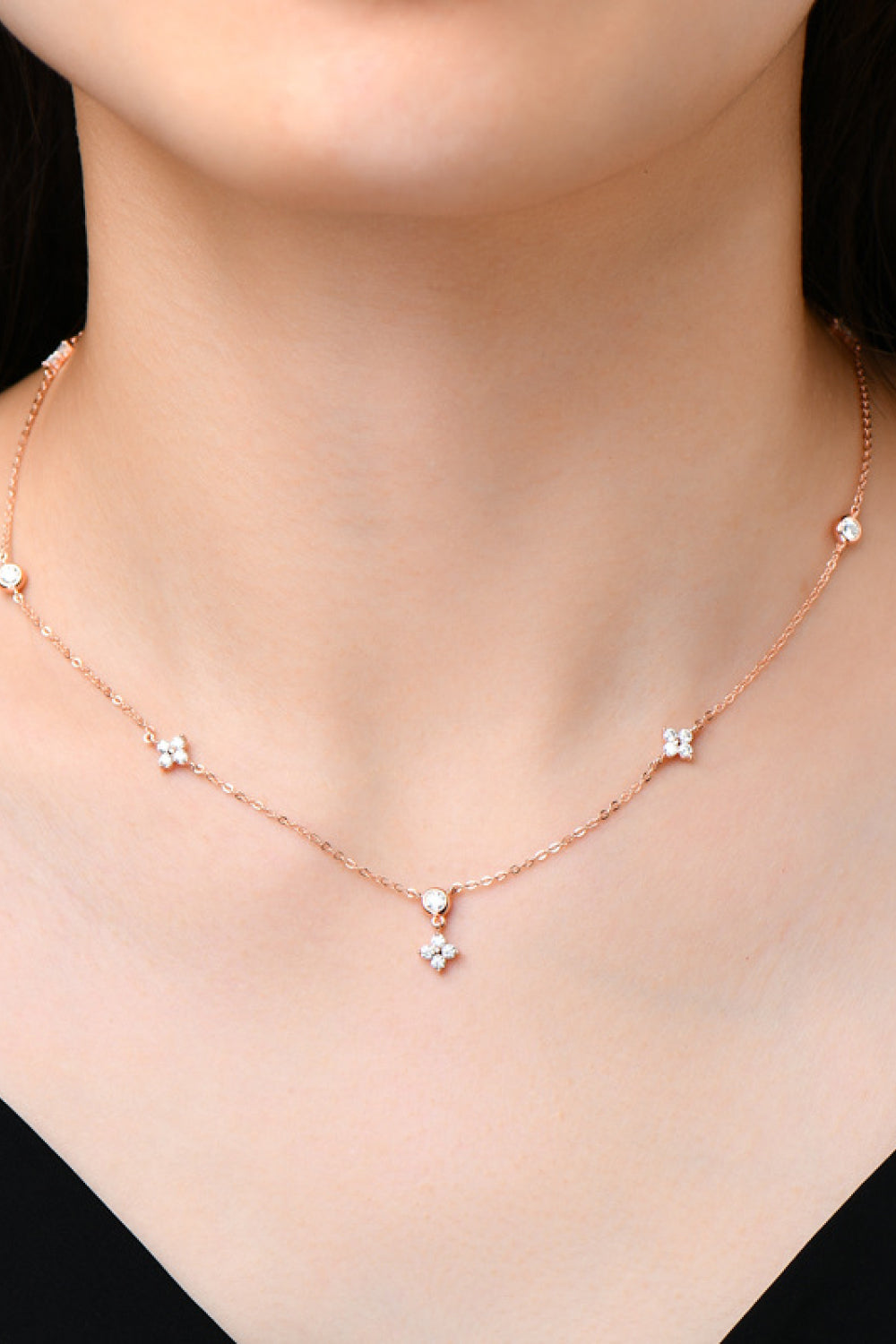 Model wearing a delicate silver-tone necklace with spaced stones