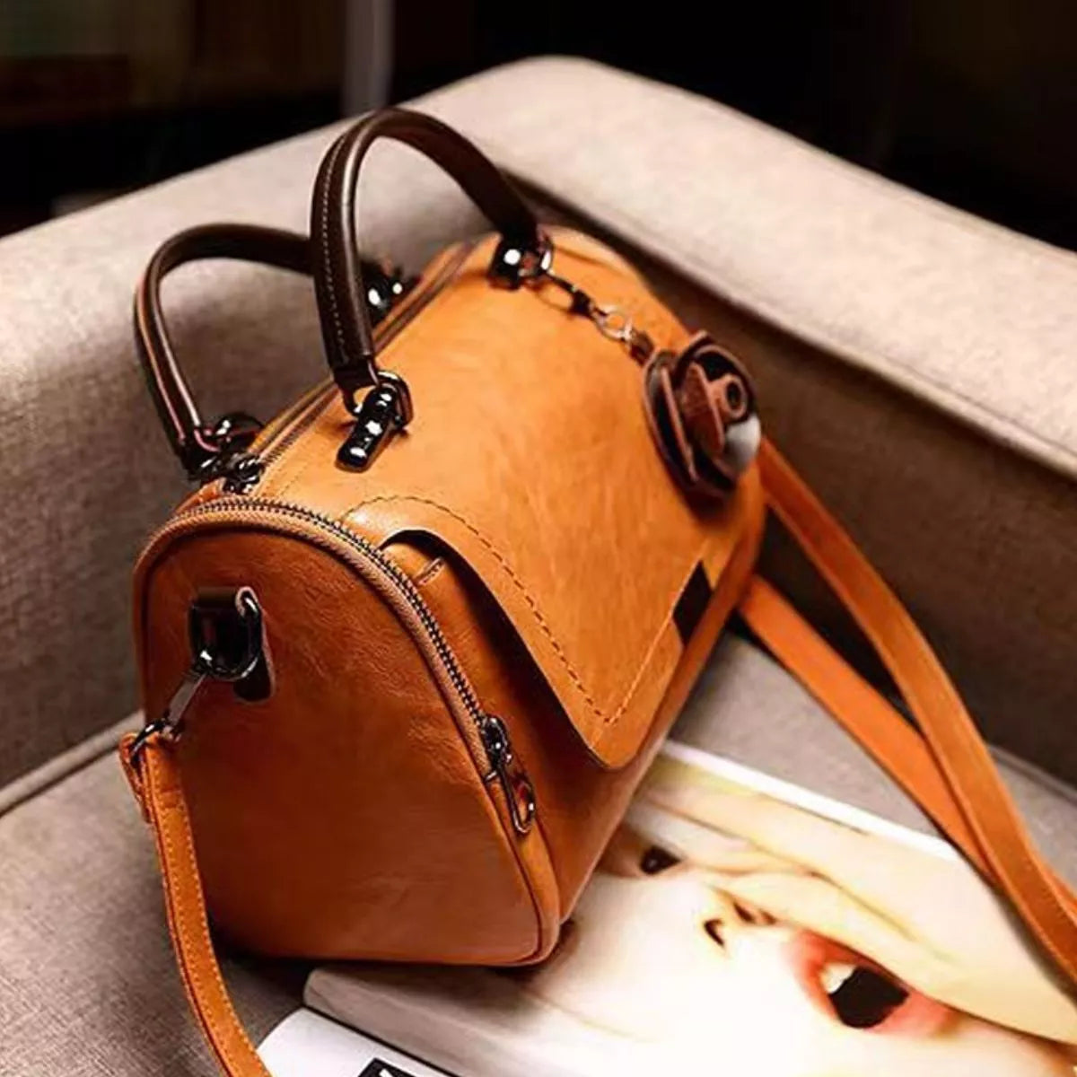 Angled view of tan flap crossbody bag showing its side panel and strap