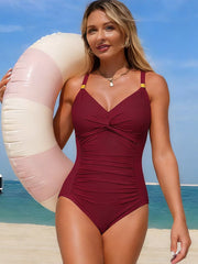 Burgundy one-piece swimsuit with a gathered bust and ruched front, modeled at the beach.
