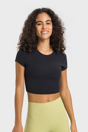 Model wearing a black cropped sports T-shirt with pale yellow leggings