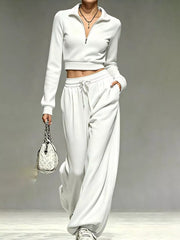 Model wearing white half-zip cropped top and matching wide-leg pants