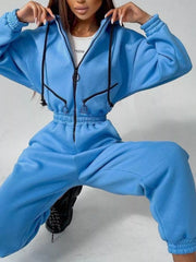 Women's hooded zip-up long-sleeve jumpsuit, blue seated view