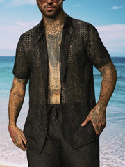 Model wearing a dark geometric-print short-sleeve button-up shirt
