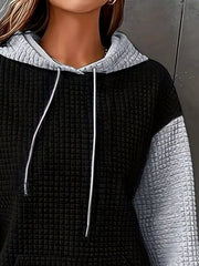 Front view of black and white color-block hooded top