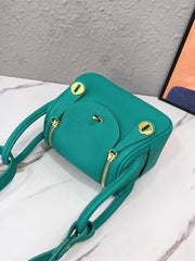 Teal crossbody bag viewed from above, showing front flap and gold-tone fittings