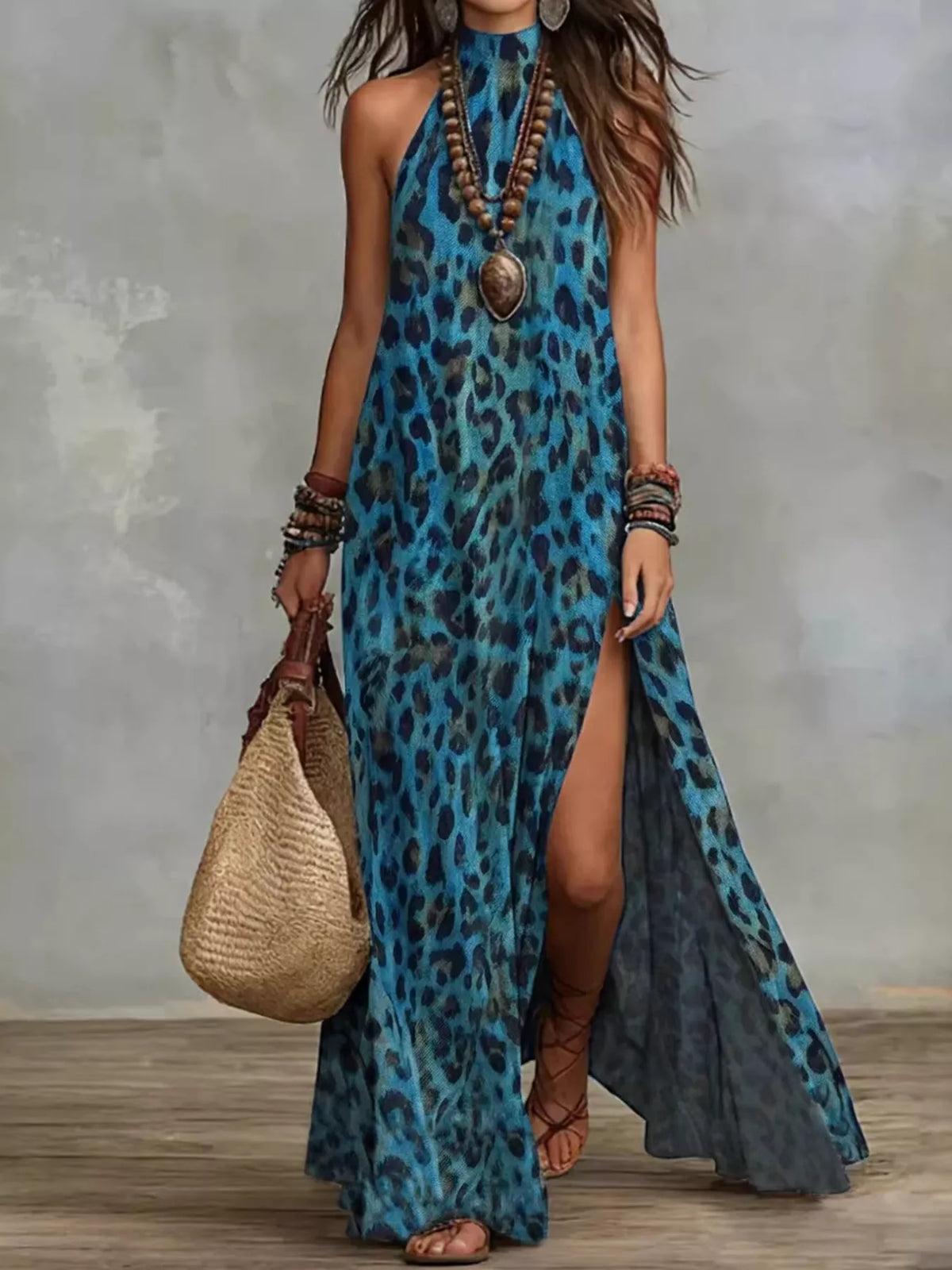 Blue leopard-print halter maxi dress with a high side slit, full-length front view with a woven bag.