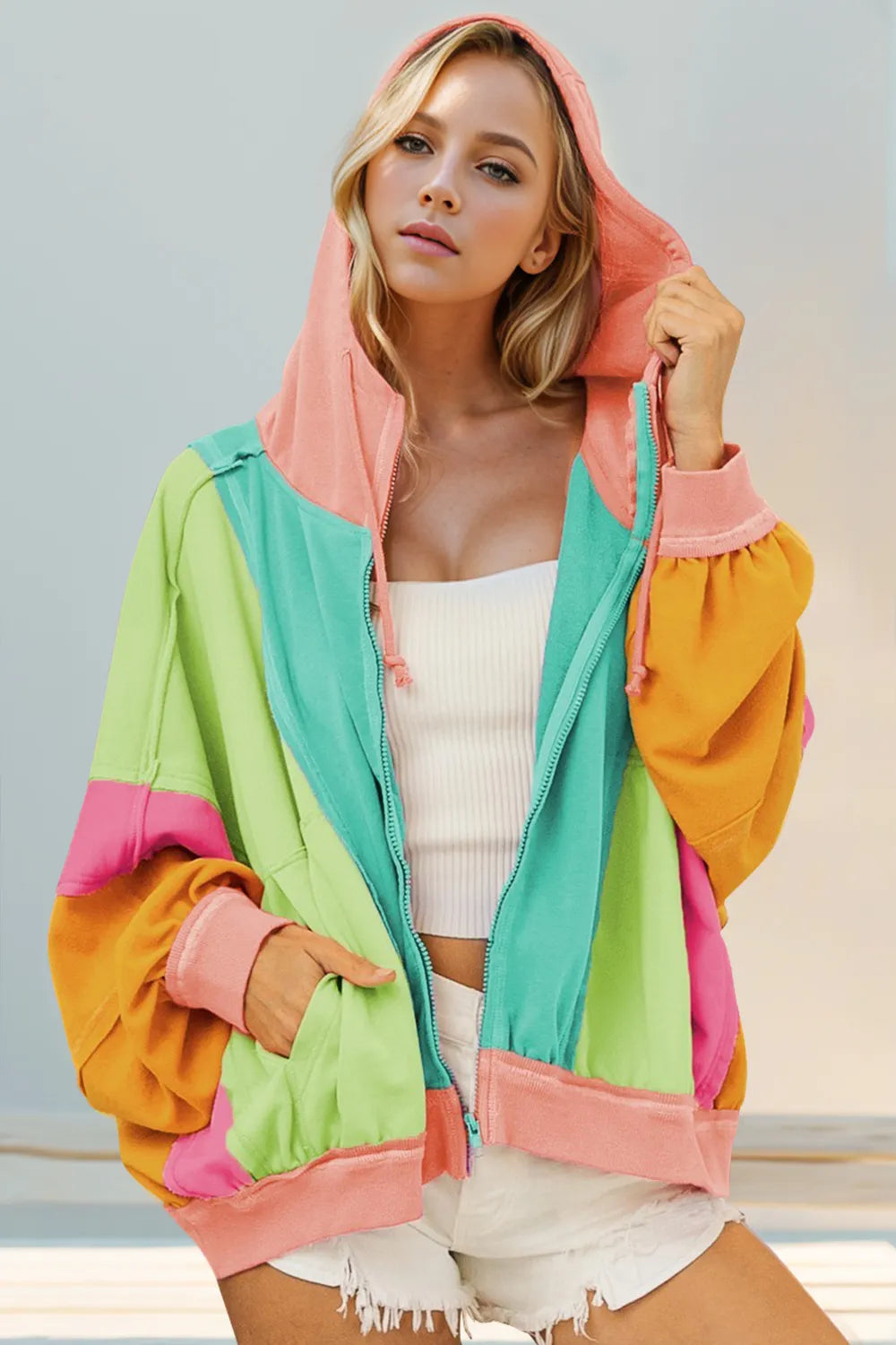 Close view of color-block hoodie's relaxed fit, ribbed cuffs, and contrasting sleeves.